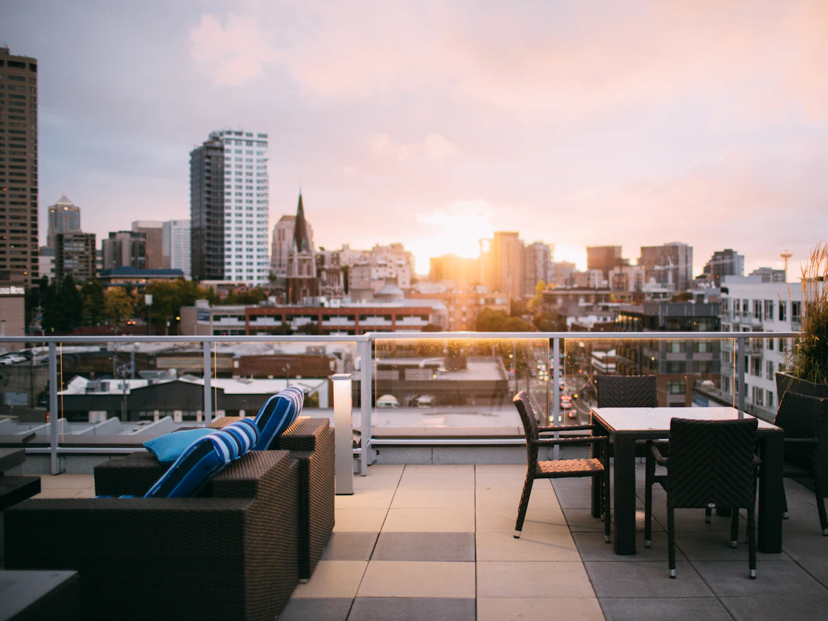 Balcón terraza con mesa y vista a la ciudad al atardecer