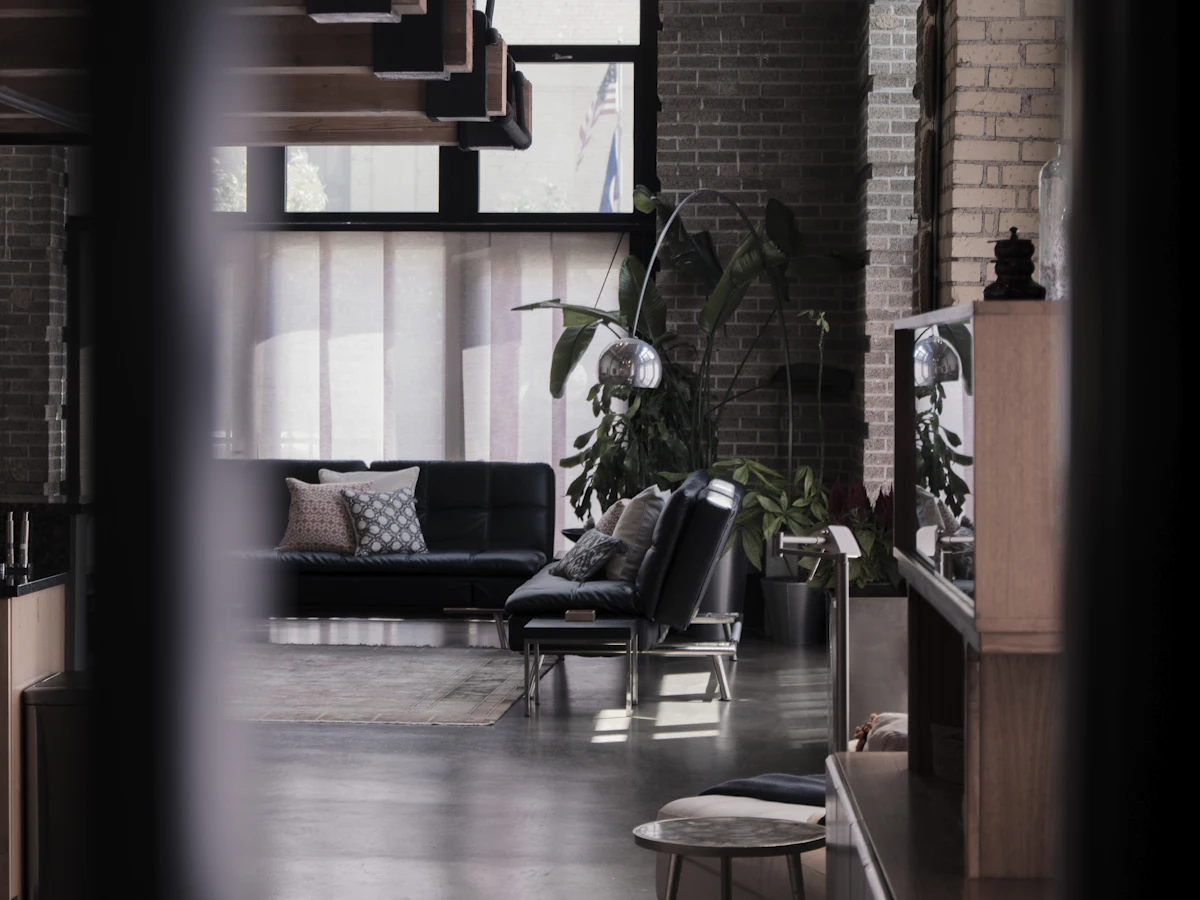 Loft con paredes de ladrillo, sillones de cuero y plantas